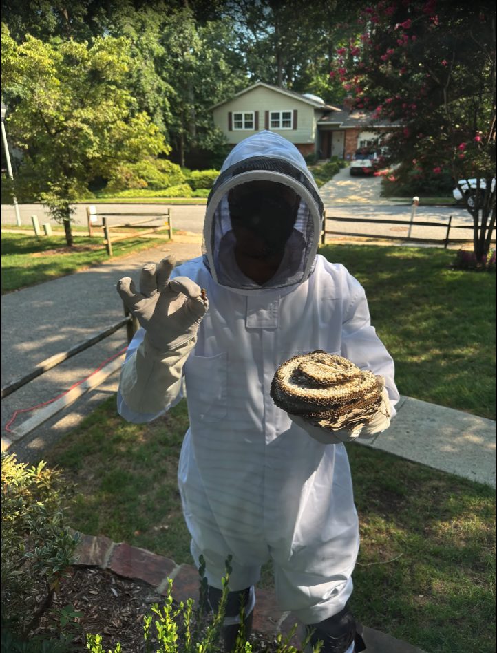 Earl of Essential Pest Control in protective gear, removing a large yellow jacket nest